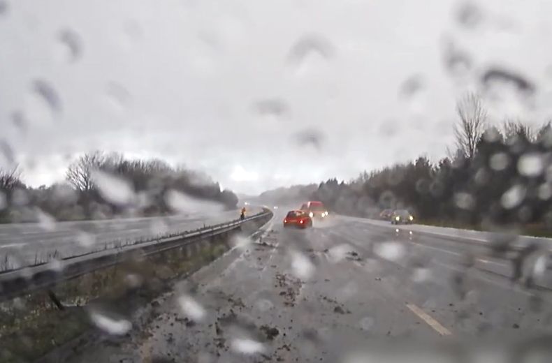Video: Car skids backwards down motorway almost hitting traffic officer
